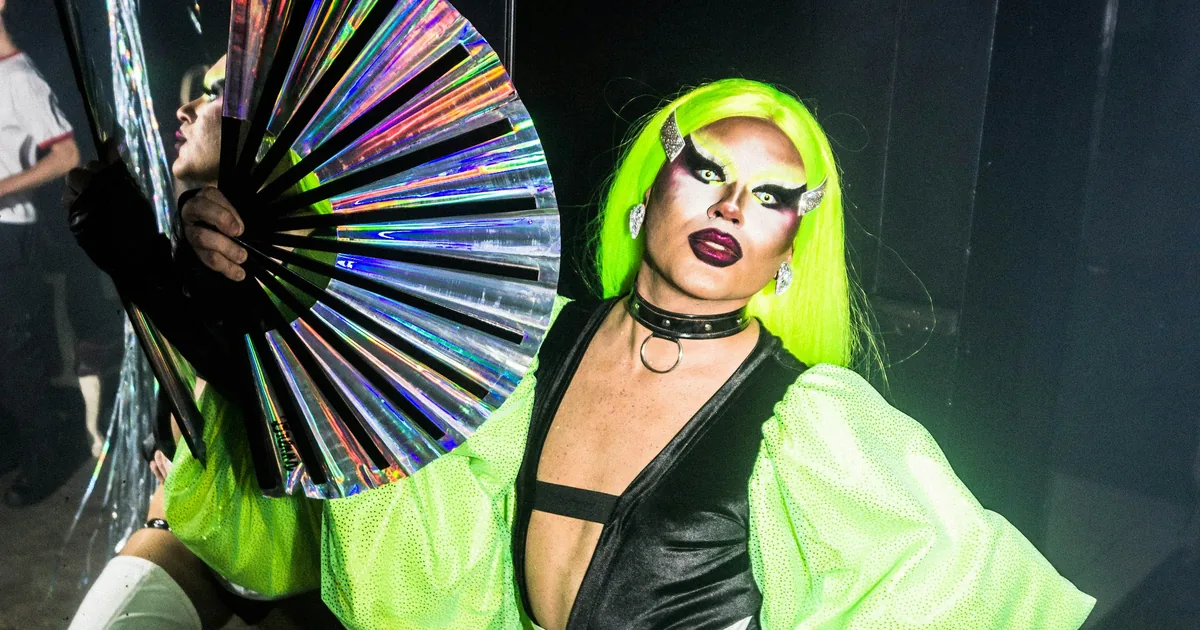 Drag Queen mit Fächer auf einer Bühne